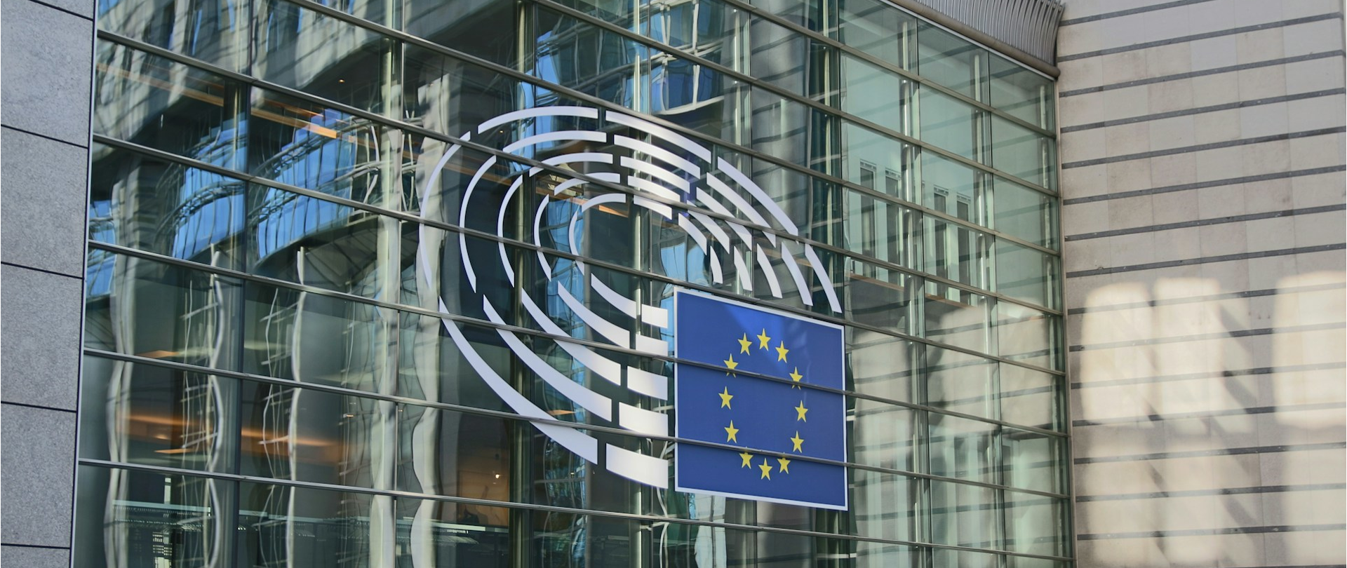 Flaga Unii Europejskiej powieszona na szklanej ścianie
