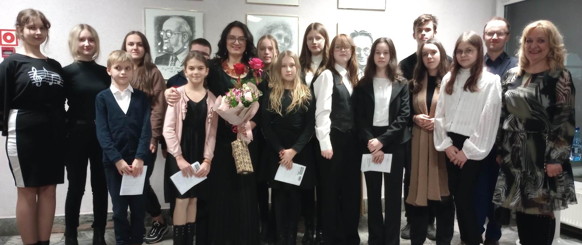Zdjęcie grupowe uczestników koncertu w Białymstoku z solistką Katarzyną Makal-Żmuda w hallu przed salą koncertową.