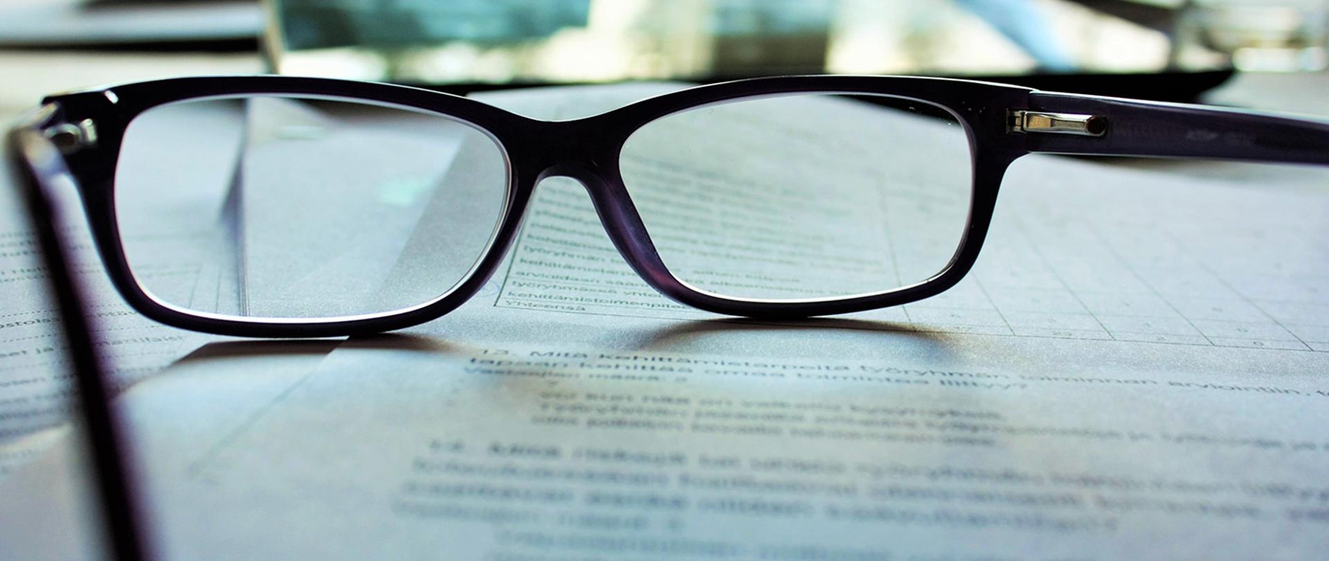 w tle okulary na dokumencie