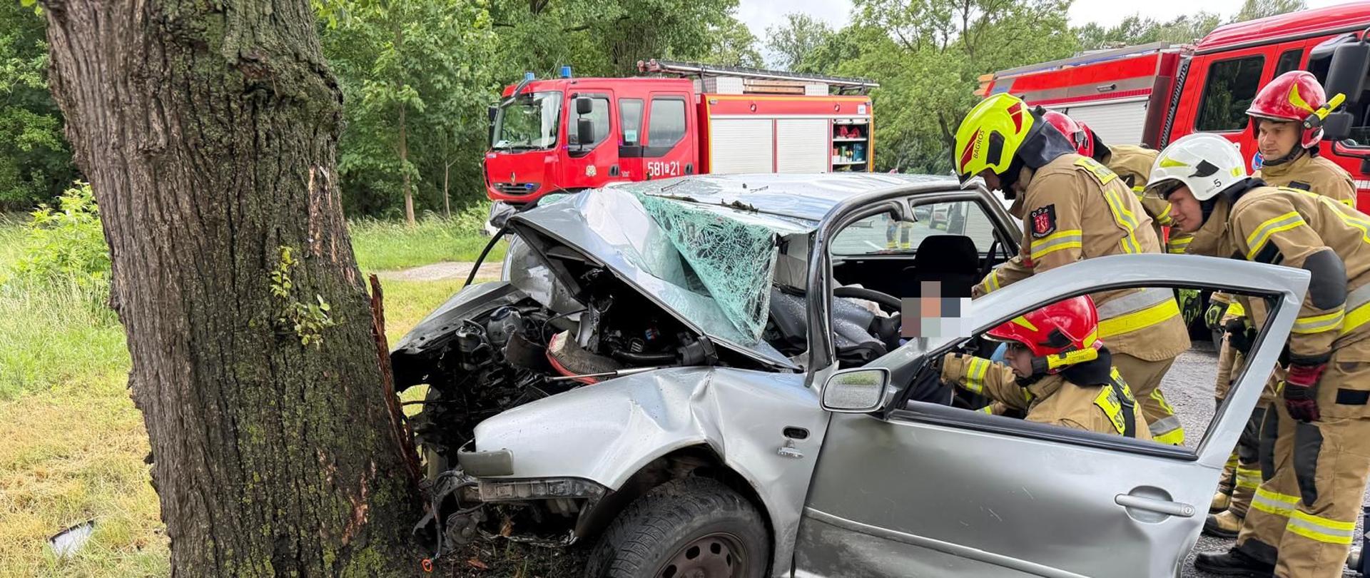 Samochód osobowy uderzył w drzewo strażacy uwalniają kierowcę