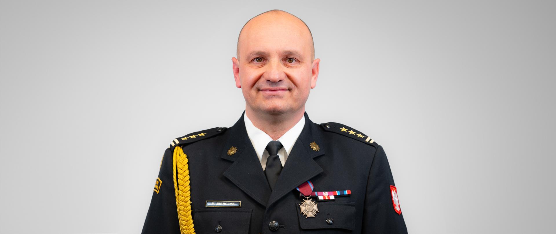 st. bryg. Maciej Bieńczyk w czarnym mundurze wyjściowym ze sznurem oficerskim