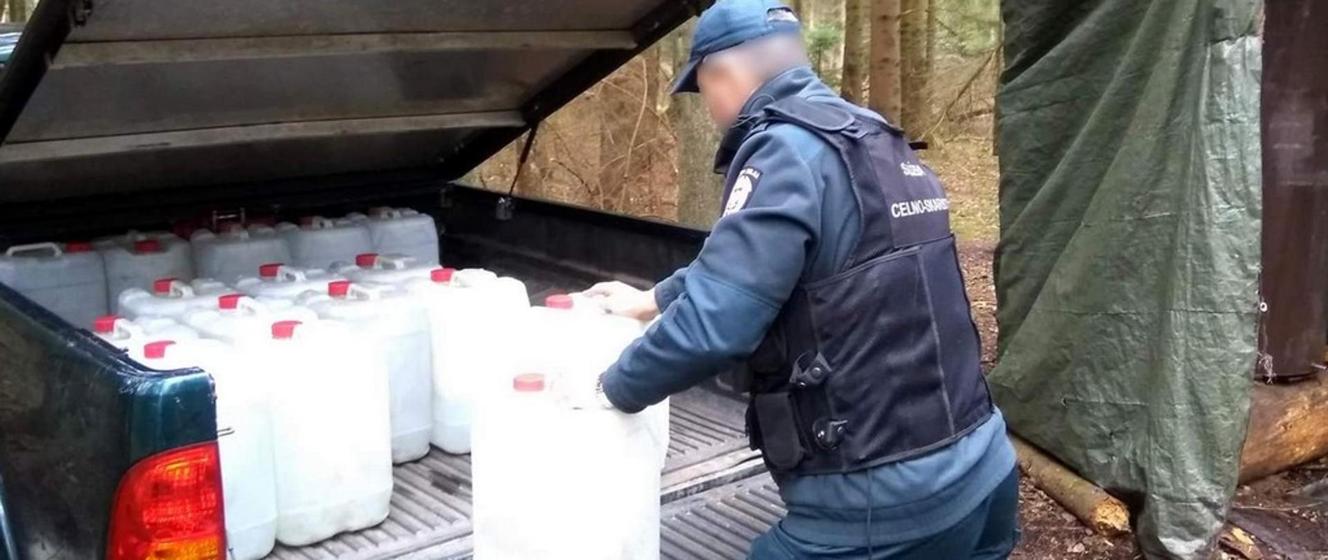 Funkcjonariusz KAS ładuje pojemniki na samochód typu pick-up