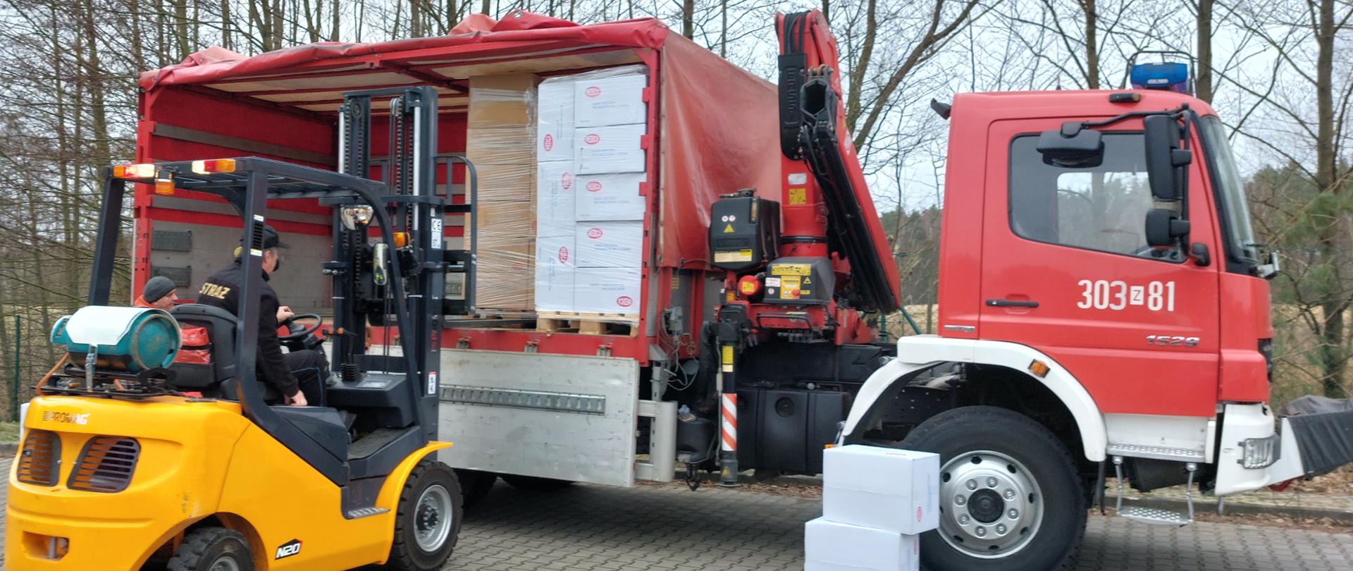 wózek widłowy ściąga paletę z kartonami z samochodu ciężarowego z HDSem 