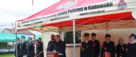 Wystąpienie przy mównicy gościa zaproszonego na uroczystość. W tle funkcjonariusze w umundurowaniu.
