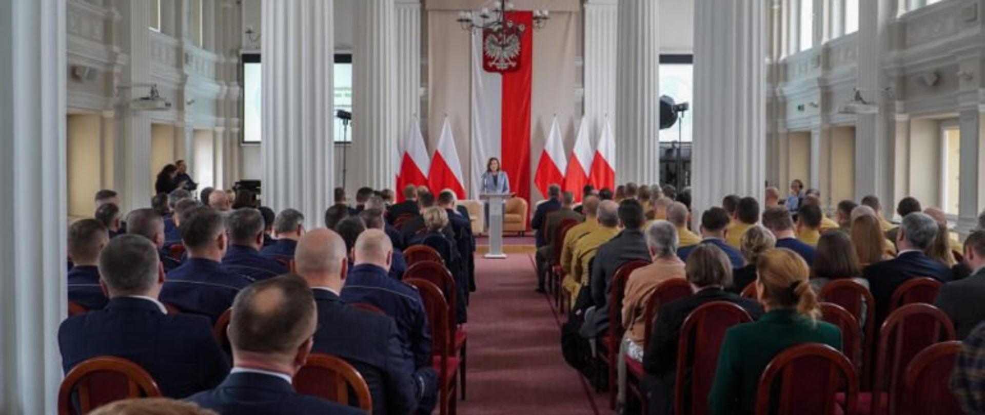 Wojewoda podkarpacki podczas wykładu na konferencji geopolitycznej w Rzeszowie. Przed przemawiająca wojewodą uczestnicy spotkania