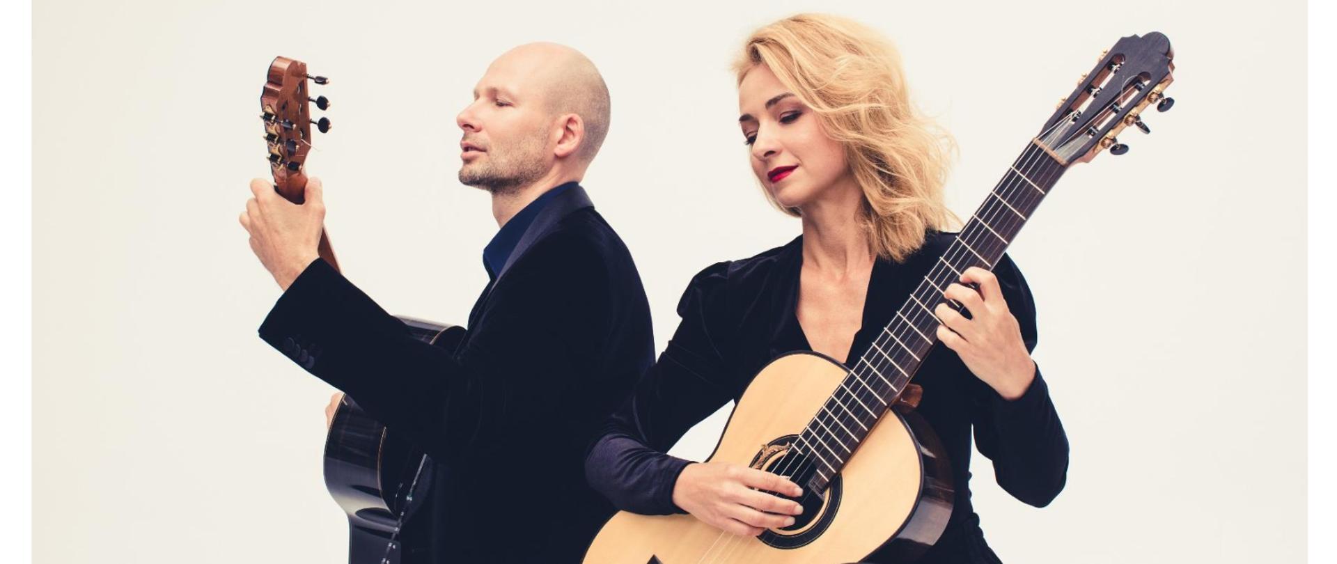 Od góry strony jest zdjęcie, na którym na pierwszym planie kobieta blondynka w ciemnym ubraniu gra na jasnej gitarze, po jej prawej stronie bokiem odwrócony mężczyzna w ciemnym ubraniu również grający na gitarze.
Pod zdjęciem znajduje się logo dwie kolorowe nutki z klawiszami fortepianowymi w środku obok napis Państwowa Szkoła Muzyczna I stopnia im. Witolda Lutosławskiego w Jaśle.
Na środku duże czerwone litery Koncert Kupiński guitar Duo. Pod spodem czarne literki na białym tle 6 grudnia 2023 roku godzina 16:15 aula PSM wstęp wolny zapraszamy.
