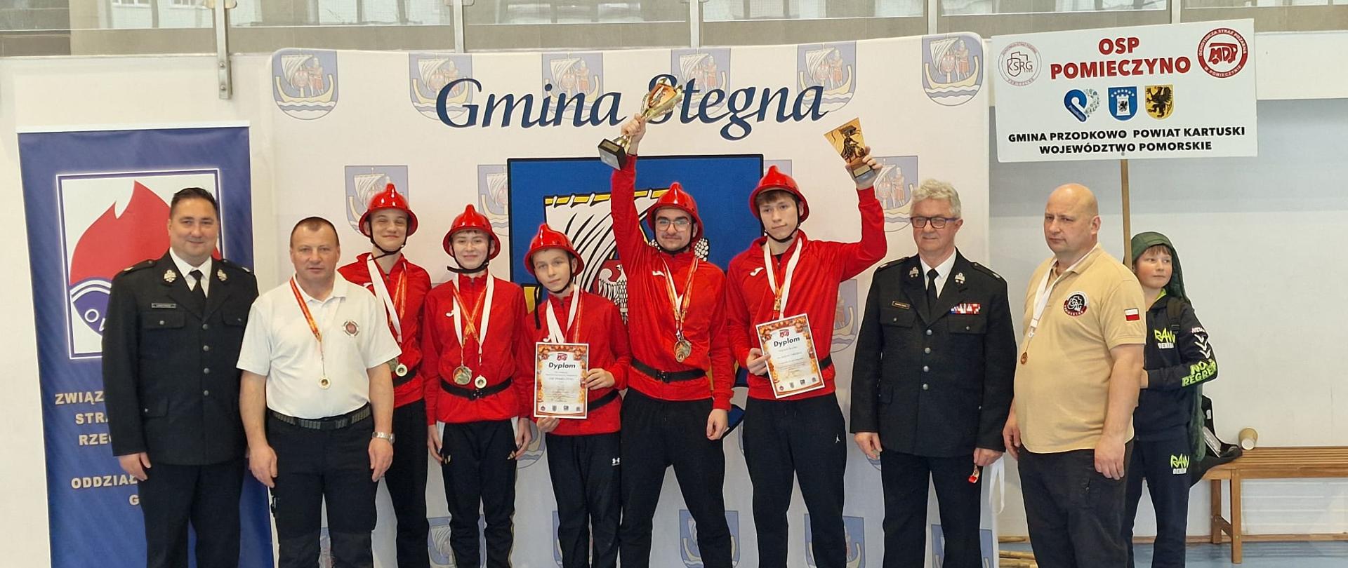 Zdjęcie przedstawia zawodników z OSP Pomieczyno z pucharem oraz dyplomem