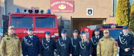 Na zdjęciu znajdują się Śląski Komendant Wojewódzki Państwowej Straży Pożarnej wraz z Komendantem Miejskim Państwowej Straży Pożarnej w Częstochowie, druhowie i druhna Ochotniczej Straży Pożarnej w Częstochowie Kuźnicy Marianowej, którzy stoją na tle budynku remizy oraz samochodów ratowniczo-gaśniczych.
