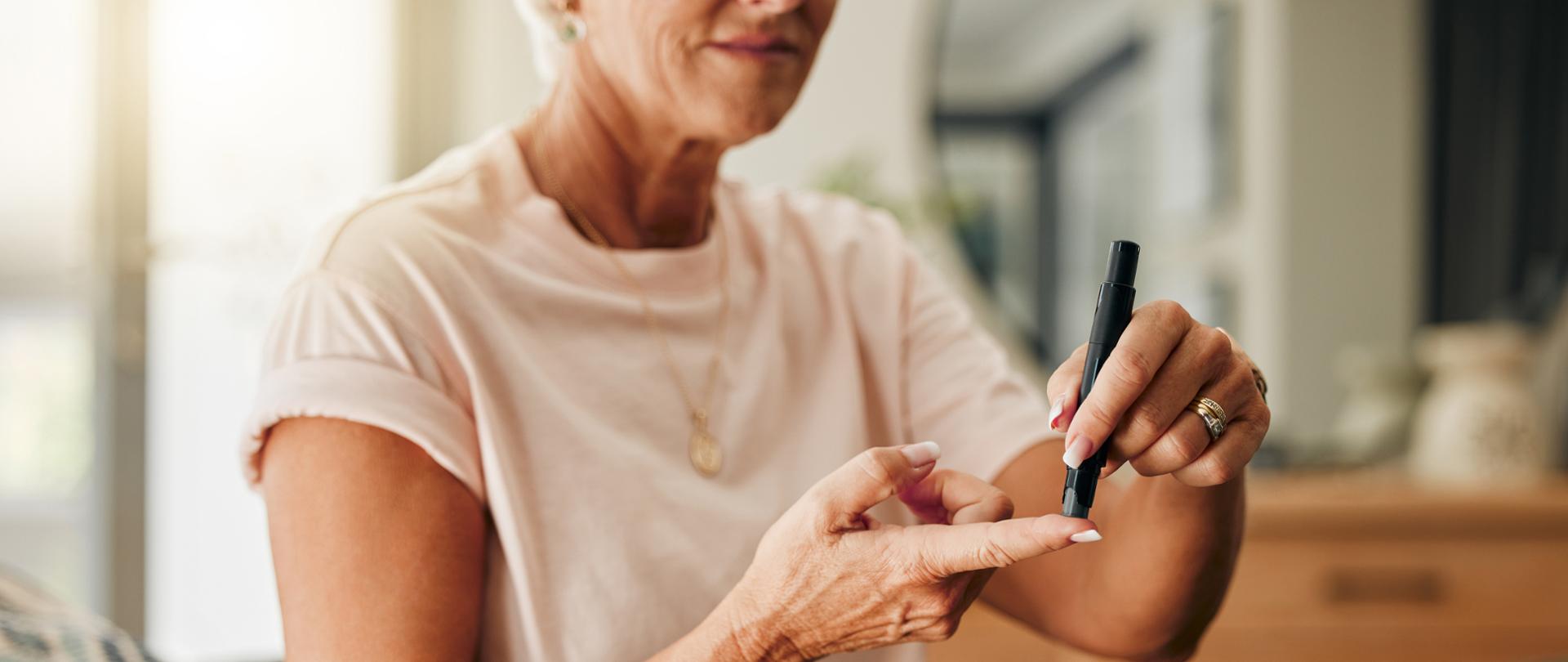 siedząca kobieta badająca sobie poziom cukru
