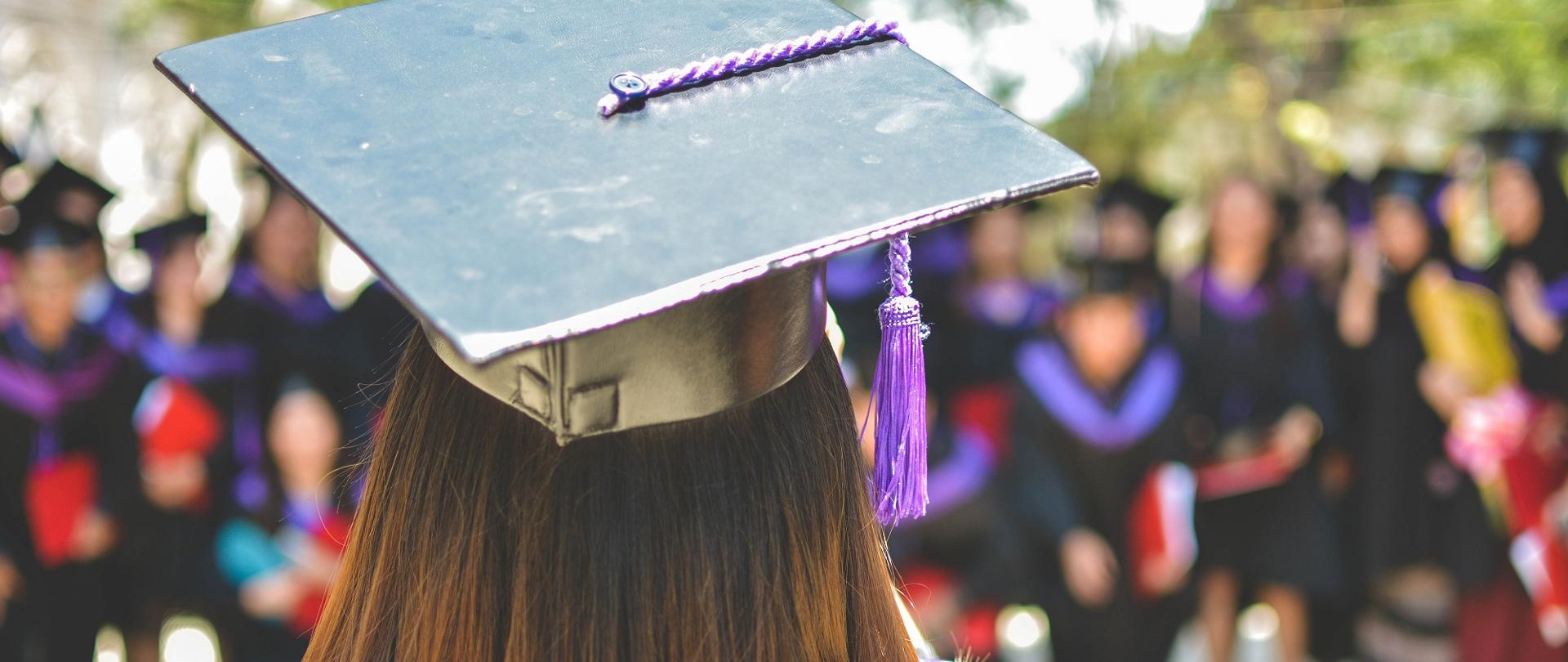 Studenci i kadra uczelni w galowych strojach.