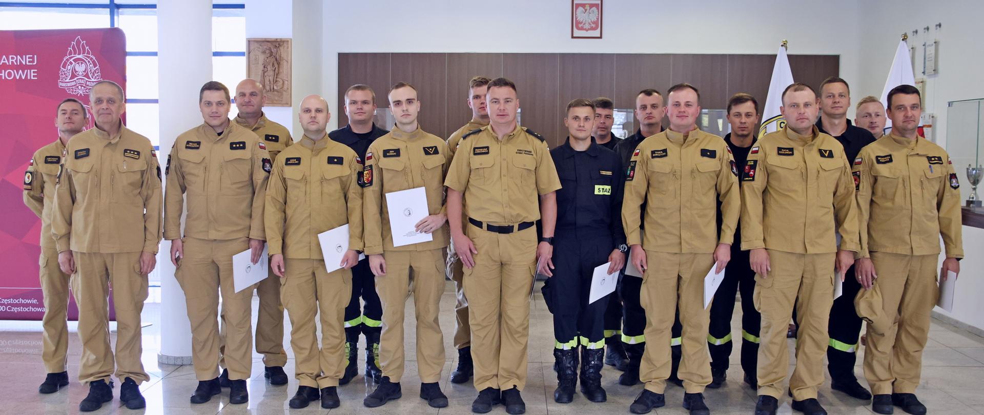 Pamiątkowe zdjęcie grupowe funkcjonariuszy PSP będących uczestnikami szkolenia (15 osób) w towarzystwie trzech oficerów CS PSP