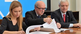 Wiceminister zdrowia Piotr Gryza oraz Anna Goławska, zastępca dyrektora Departamentu Funduszy Europejskich i e-Zdrowia podpisują umowę z przedstawicielem jednej z 16 instytucji, które otrzymały dofinansowanie.