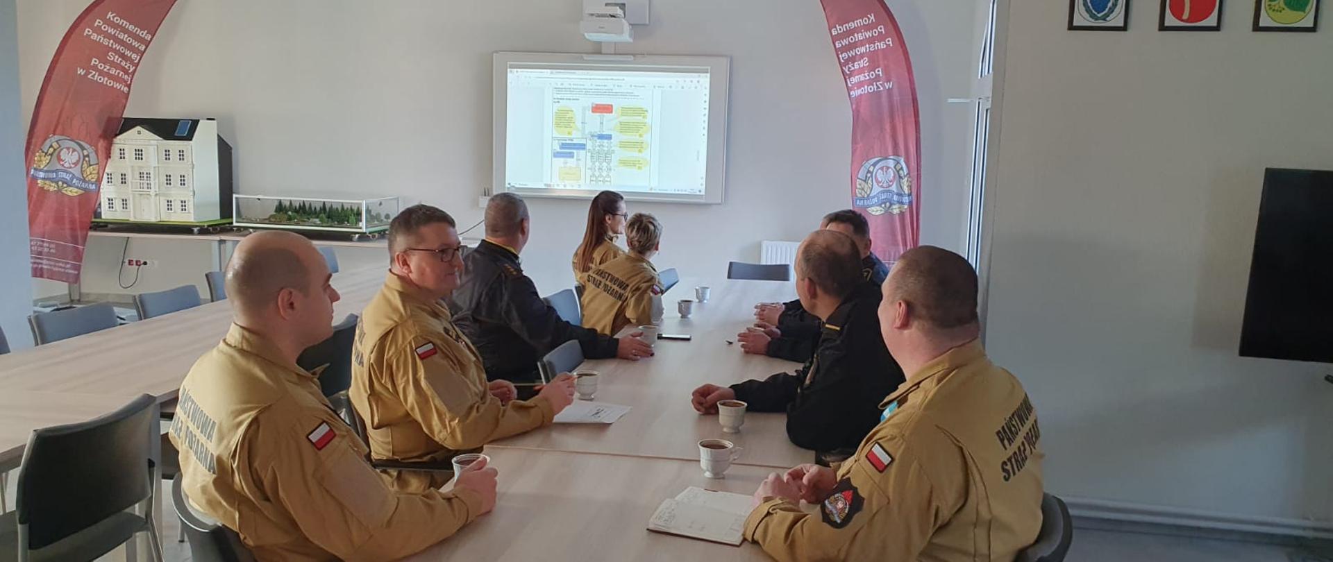 Na zdjęciu przy stole strażacy