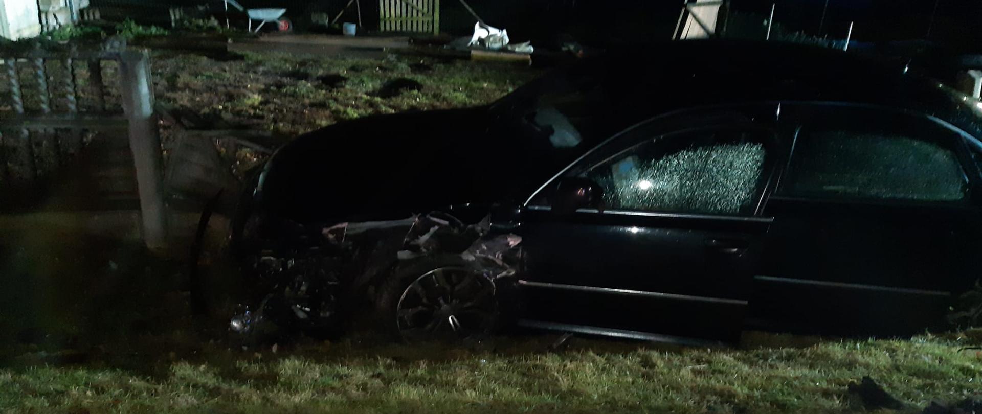 Na zdjęciu po za drogą krajową numer dwanaście doszło do kolizji drogowej dwóch samochodów osobowych marki Audi. Jeden z samochodów wypadając z drogi uszkodził betonowe ogrodzenie przy posesji. 