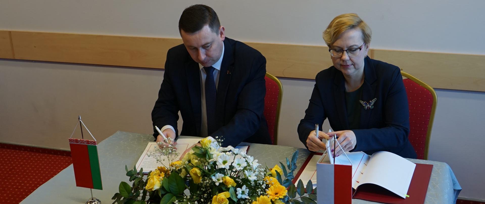 Anna Moskwa, podsekretarz stanu MGMiŻŚ i Andrei Khmel, zastępca ministra zasobów naturalnych i ochrony środowiska Republiki Białorusi podpisują porozumienie 