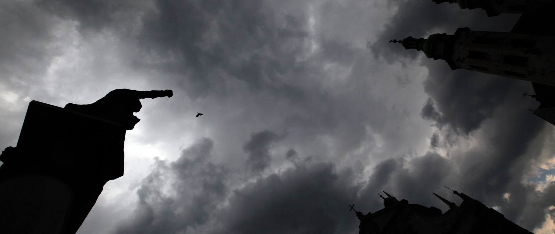 Pomnik Adama Mickiewicza na krakowskim rynku - widok od dołu na pochmurne niebo