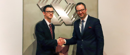 Karol Okoński (wiceminister cyfryzacji) i Marek Dietl (prezes GPW) ściskają sobie dłonie.