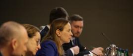 Na zdjęciu minister Katarzyna Pełczyńska-Nałęcz siedzi za stołem w towarzystwie innych uczestników konferencji