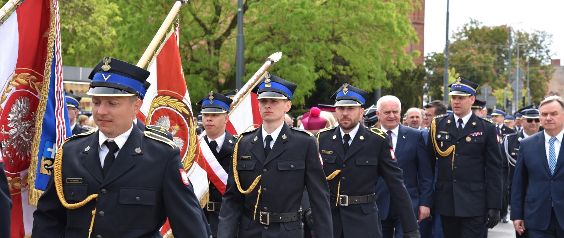 Wojewódzkie Obchody Dnia Strażaka w Gorzowie Wielkopolskim, przemarsz, widok na strażaków w tle wojewoda lubuski