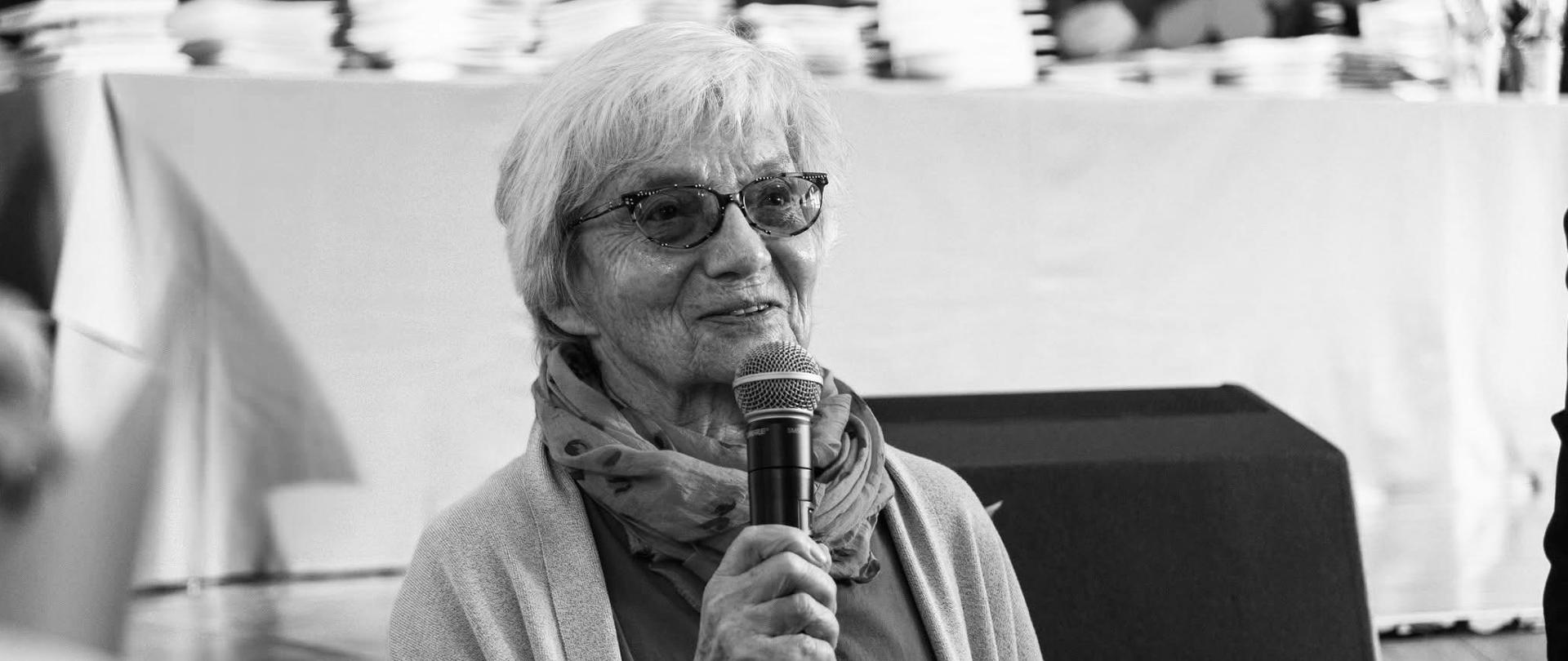 zdjęcie Piotr Witkowski, ostatnie pożegnanie, absolwentka szkoły - Agnieszka Byrska z mikrofonem w auli szkolnej