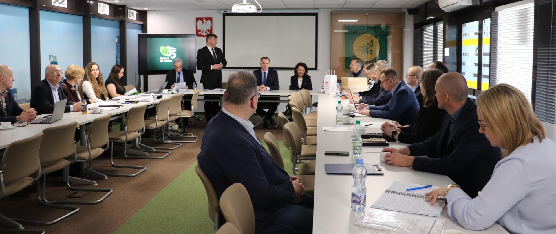 Grupa ludzi przy stole prezydialnym