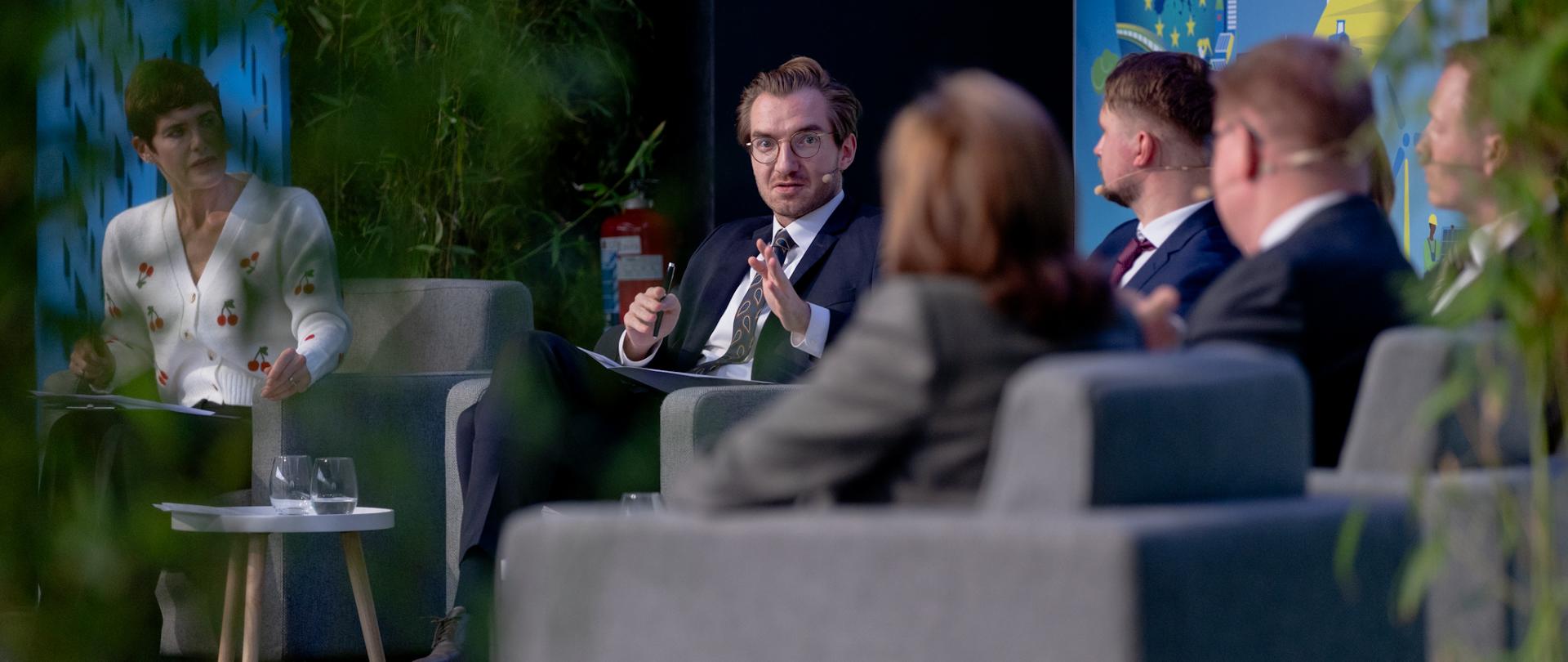 Grupa osób siedzi w fotelach i rozmawia. Drugi od lewej wiceminister Jan Szyszko.