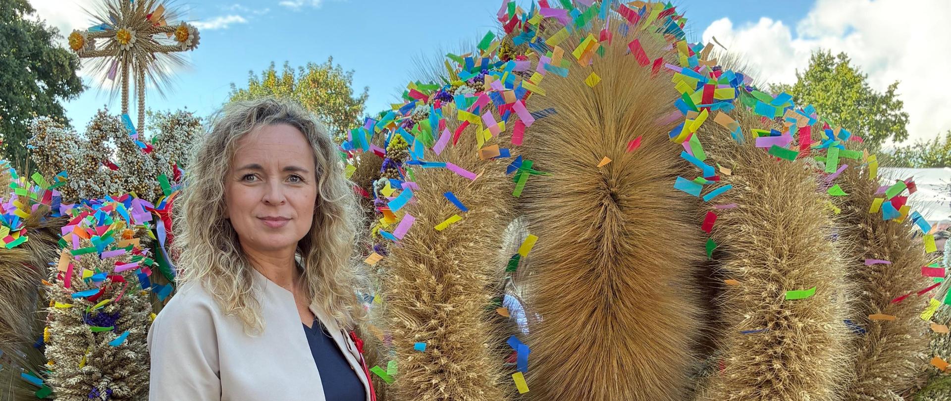 Wojewódzka Inspektor Ochrony Roślin i Nasiennictwa we Wrocławiu Bernadeta Kucharska stojąca obok wieńca dożynkowego