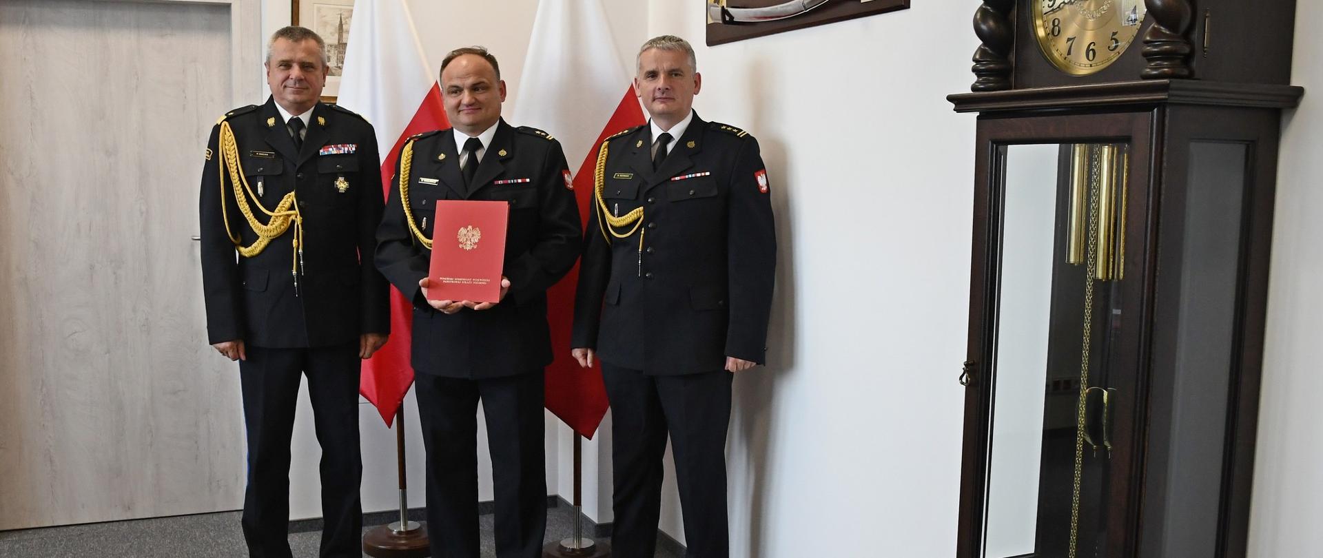 Pomorski Komendant Wojewódzki PSP powierza obowiązki nowemu zastępcy komendanta powiatowego PSP w Człuchowie - na zdjęciu widoczni PKW, Komendant Powiatowy PSP w Człuchowie i jego nowy zastępca