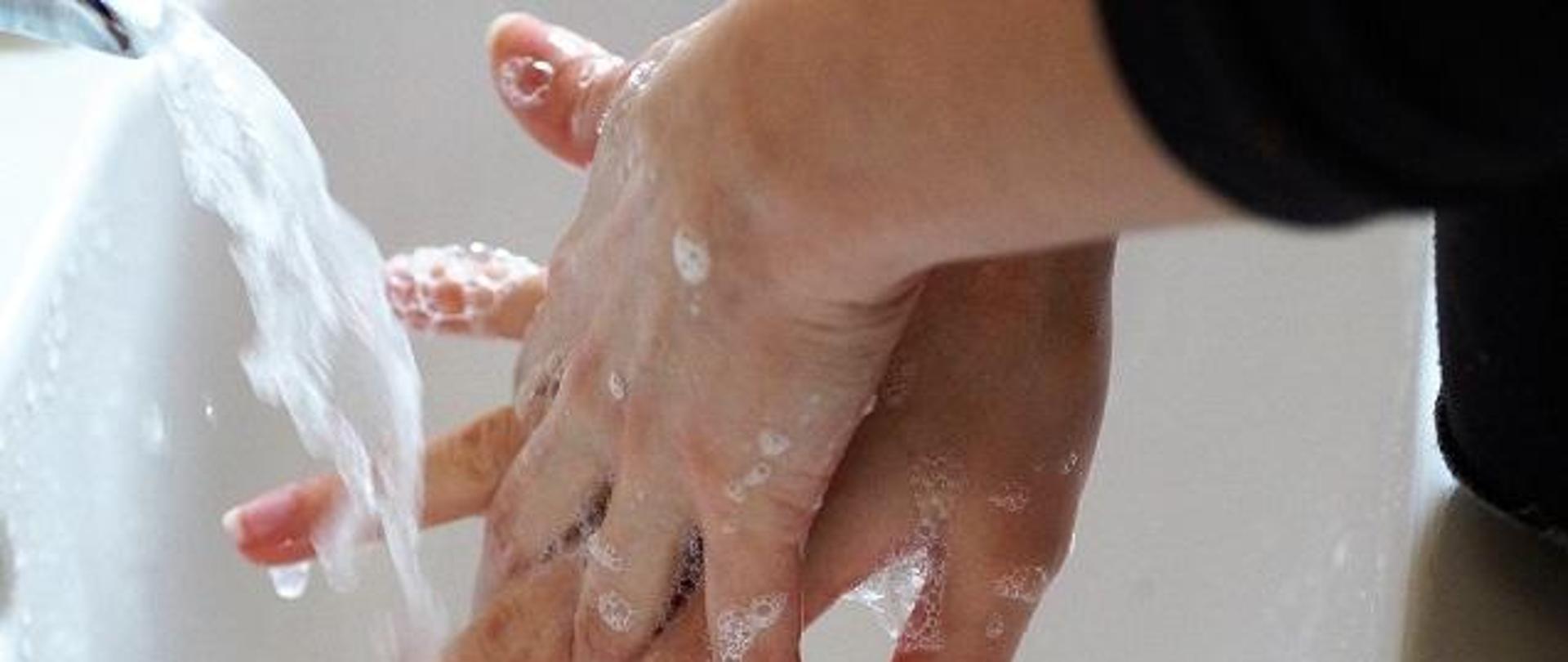 mycie rąk mydłem przy umywalce. 