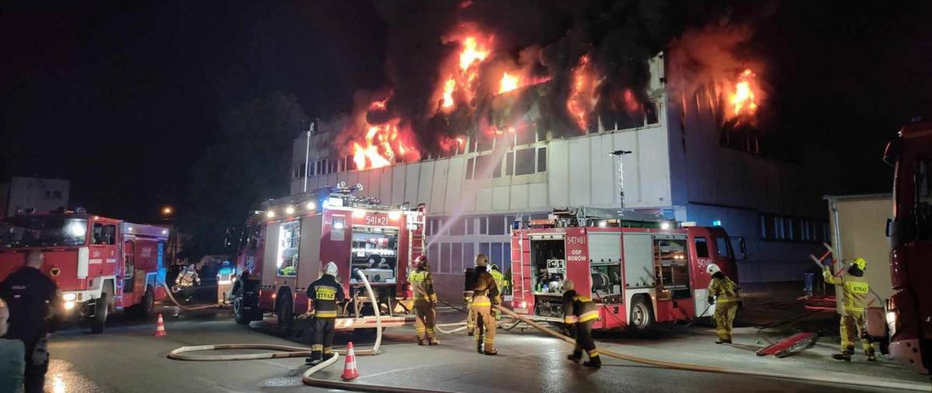 Strażacy gaszący pożar budynku