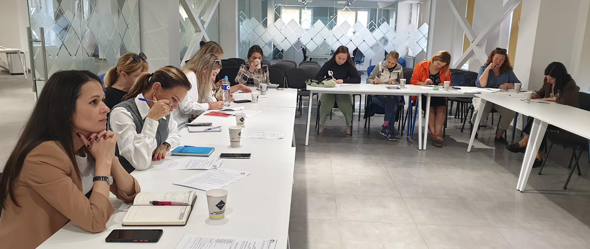 Women sit at a table arranged in a "U" shape