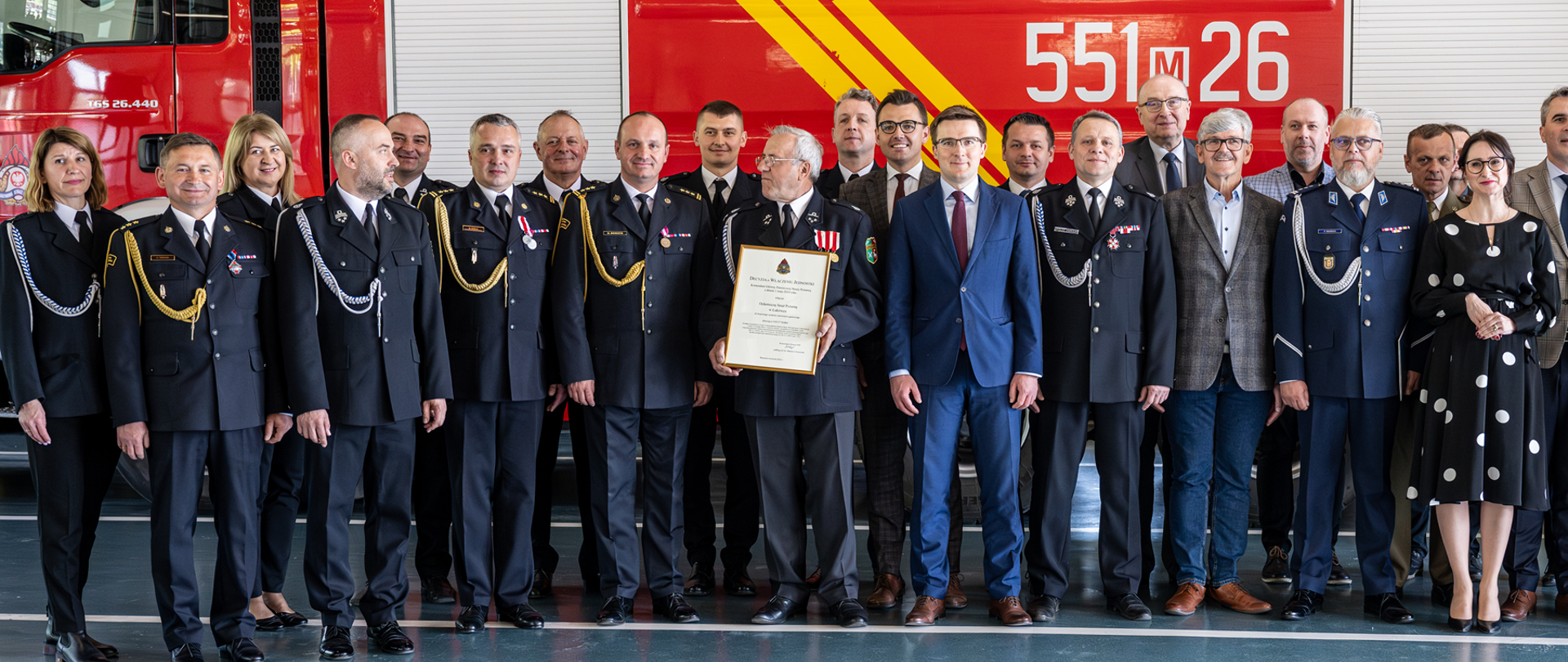 Funkcjonariusze PSP, Druhowie OSP oraz Włodarze Samorządowi na tle samochodu pożarniczego