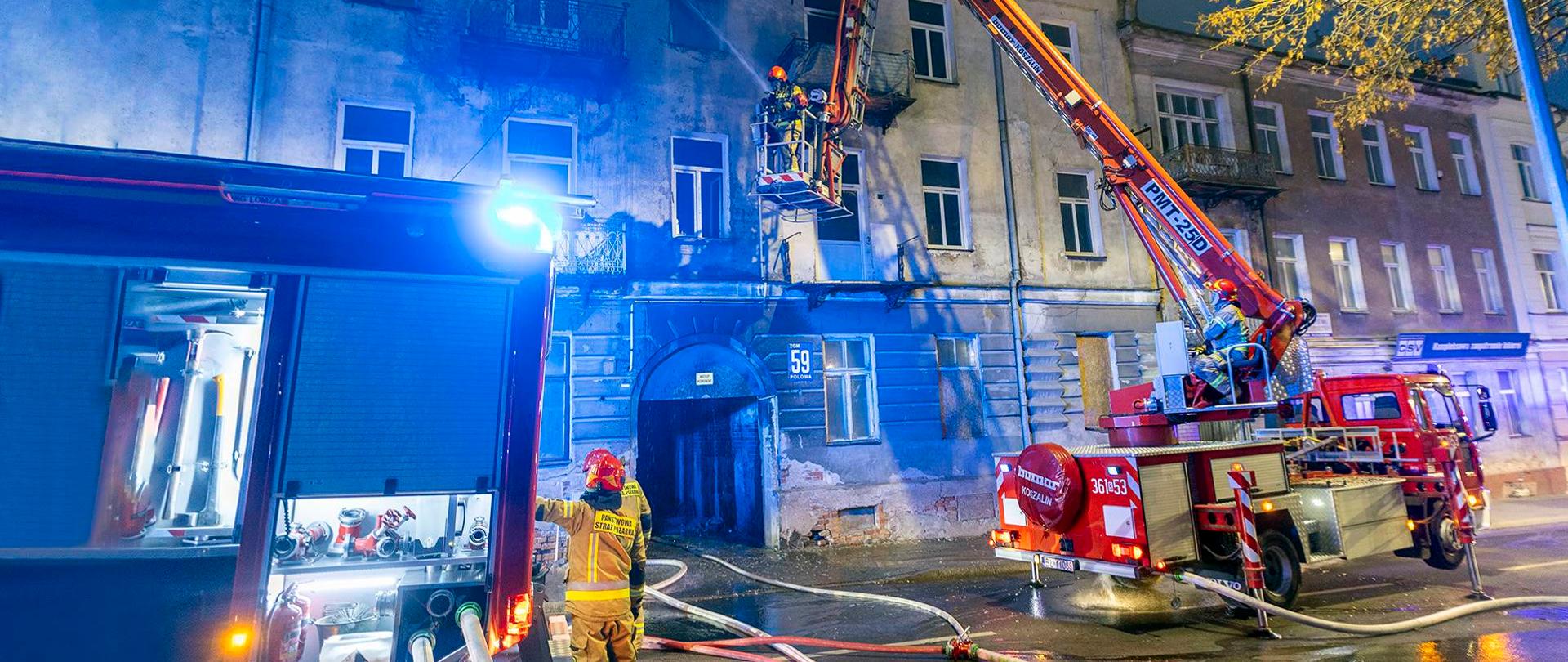 Na zdjęciu dwa zastępy JRG Łomża - pojazd gaśniczy i podnośnik. W koszu podnośnika działania gaśnicze prowadzą dwaj strażacy.