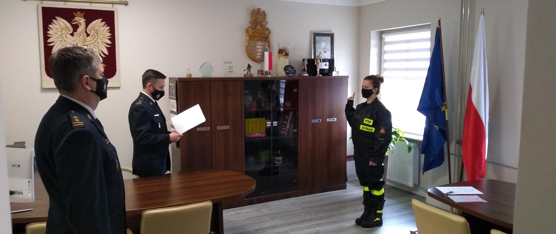 Zdjęcie przedstawia nowoprzyjętą funkcjonariuszkę składającą ślubowanie. Ślubowanie przyjmuje Komendant Miejski Państwowej Straży Pożarnej w Chorzowie brygadier Paweł Nalepka.