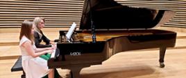 Uczennica z Panią Iwoną Ulbrich grające na fortepianie na scenie sali koncertowej PSM