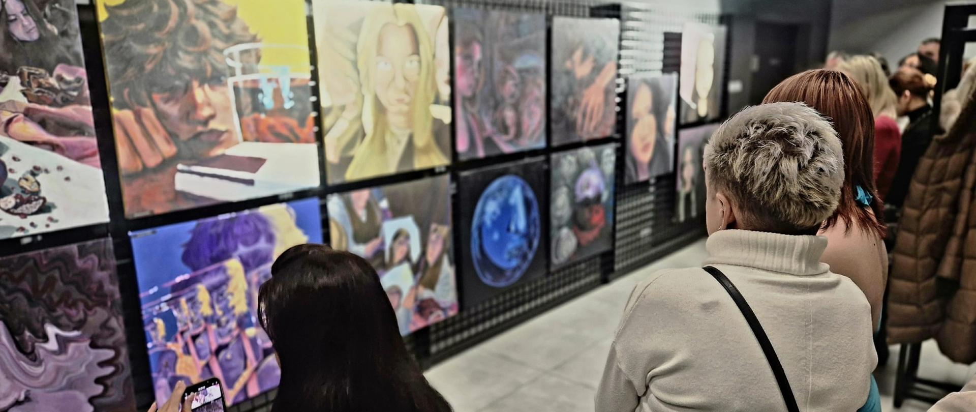 Grupa ludzi obserwujących prace uczniów