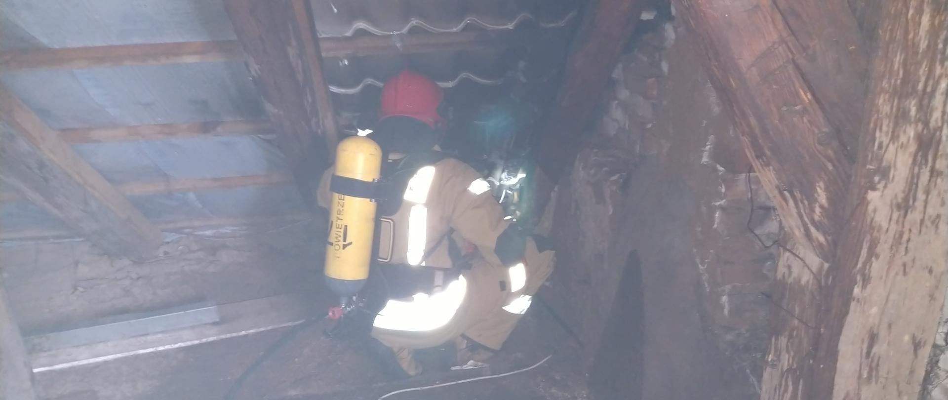 Strażak gaszący poddasze