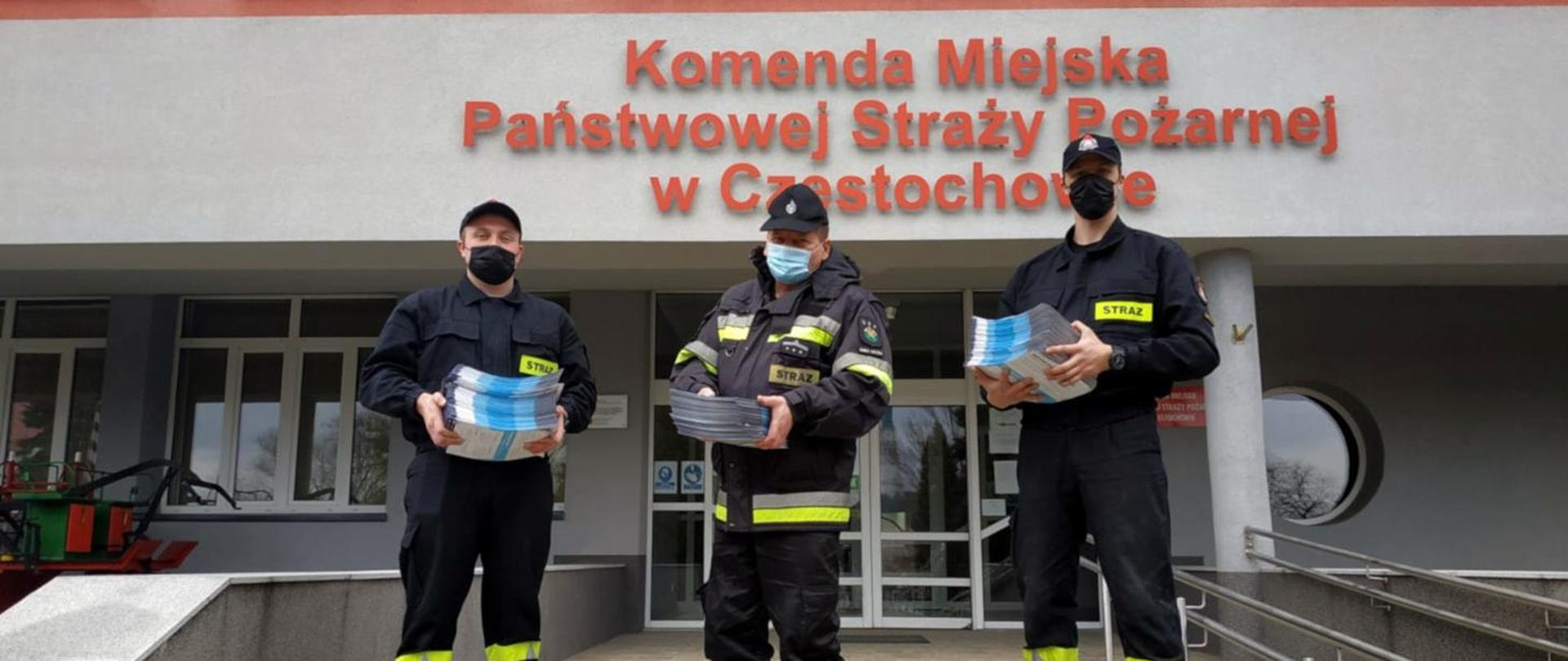 Zdjęcie przedstawia trzech strażaków trzymających ulotki.