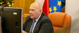minister Tadeusz Kościński przed monitorem uczestniczy w konferencji online