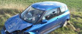 Widać niebieski samochód z uszkodzonym przodem od strony kierowcy