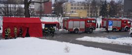 Strażacy PSP i OSP kończą rozstawianie namiotu na wyznaczonym parkingu. 2 samochody ratowniczo – gaśnicze.
