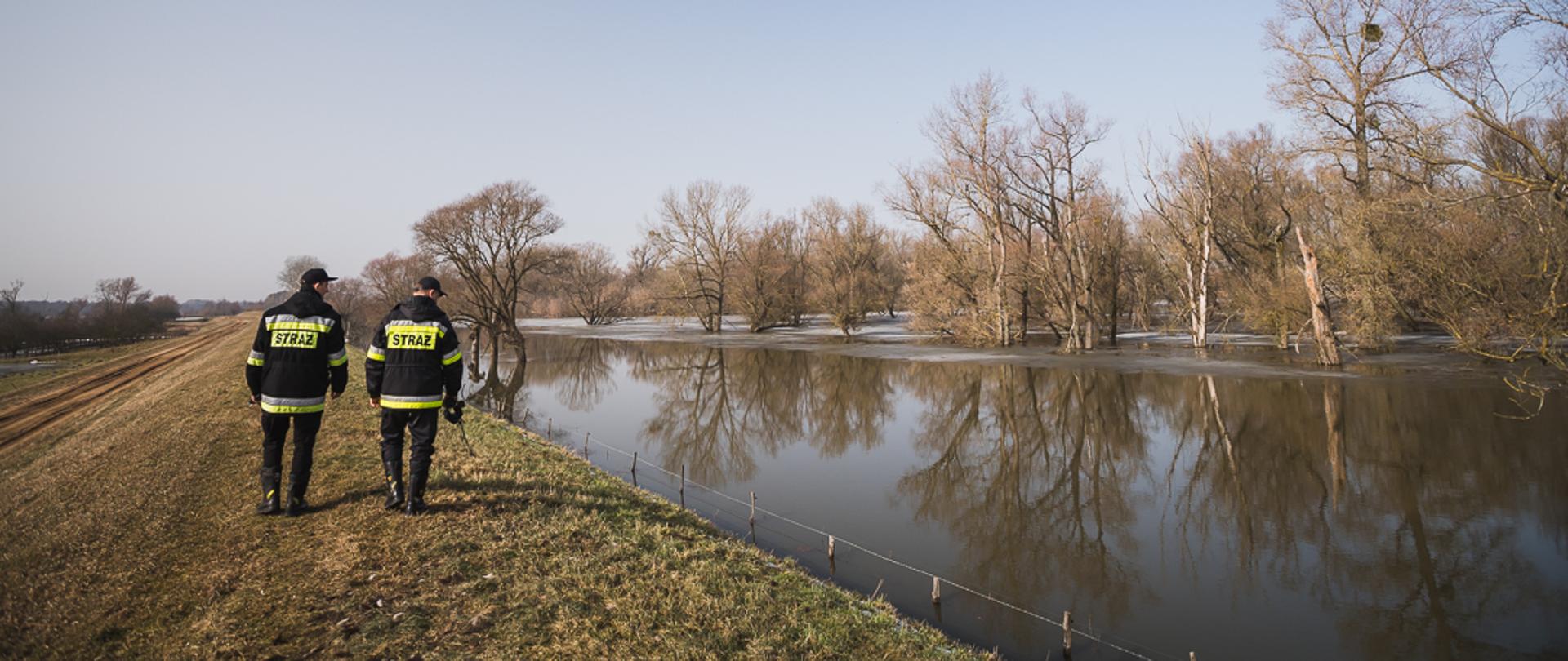 Na zdjęciu dwóch strażaków na patrolu wałem przeciwpowodziowym