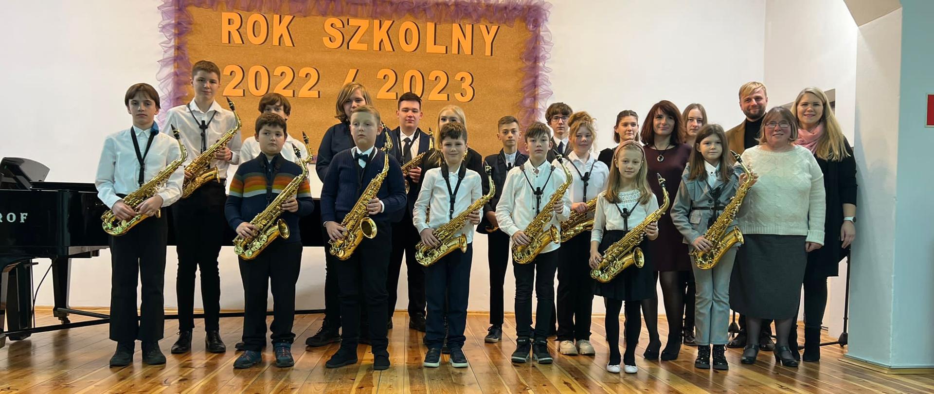 Saksofoniści wraz z nauczycielami na scenie