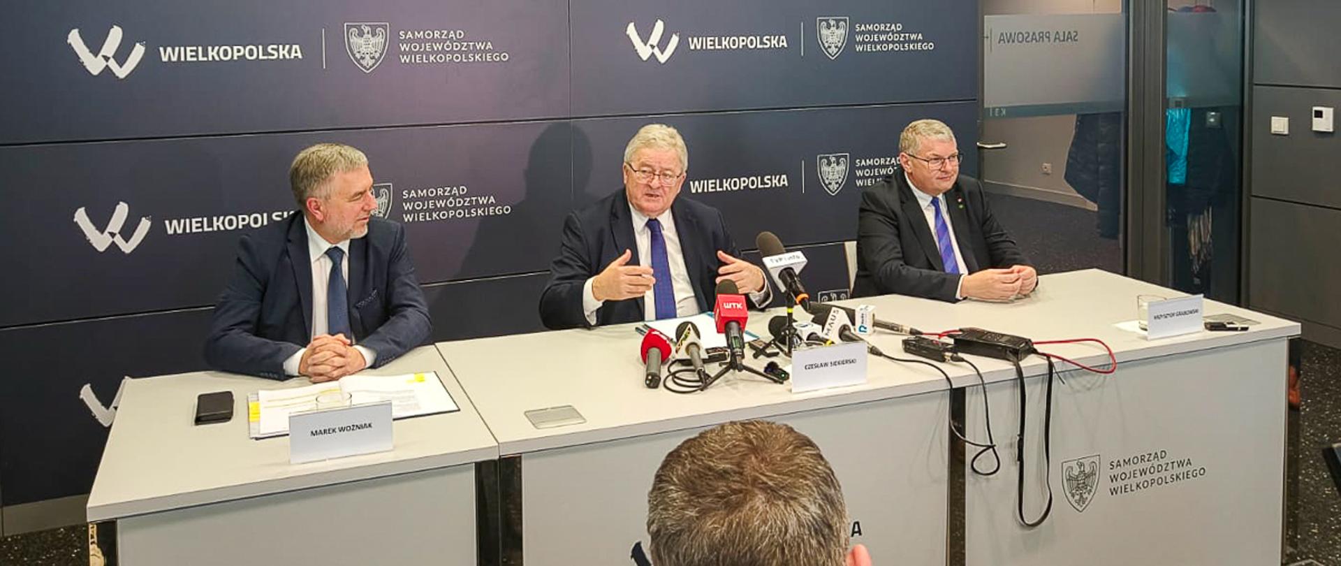 Minister Czesław Siekierski podczas konferencji prasowej, siedzący za stołem prezydialnym