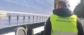 Inspektor Ochrony Środowiska na tle naczepy ciężarówki
