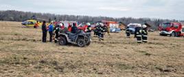 Na zdjęciu znajduje się quad, śmigłowiec LPR samochody pożarnicze oraz strażacy i ratownicy medyczni.