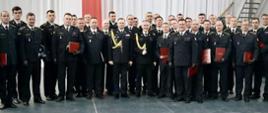 Zdjęcie przedstawia kilkunastu strażaków po obronie i otrzymaniu dyplomu. Strażacy dumni i zadowoleni.