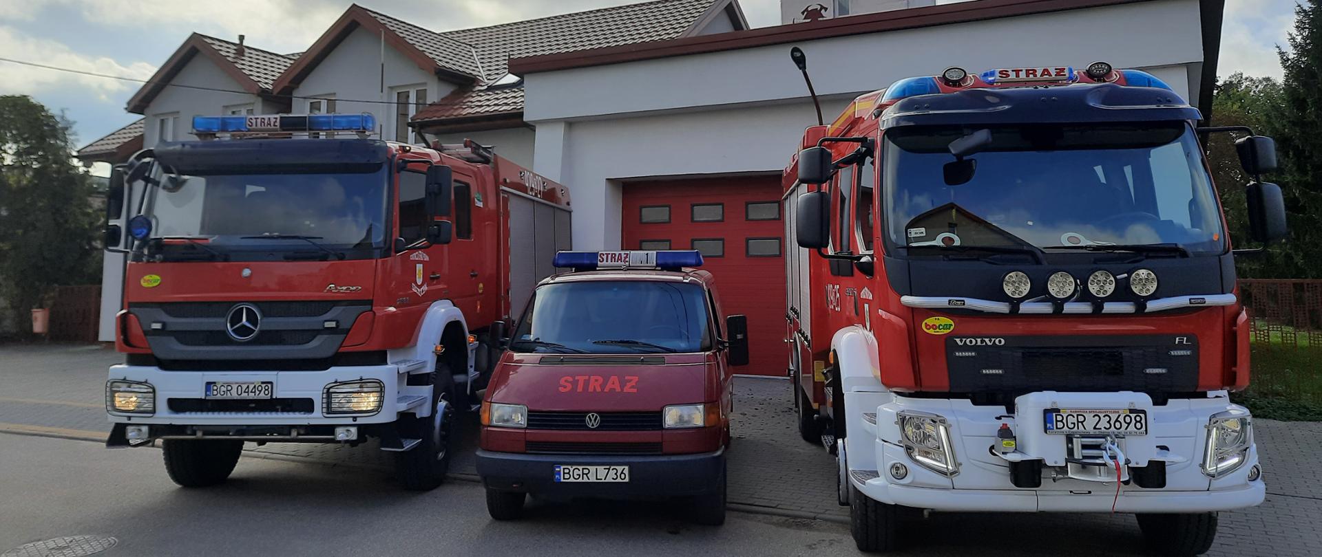 Pojazdy OSP KSRG Szczuczyn stojące przed remizą.