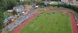 Widok z lotu ptaka. Tory do ćwiczenia bojowego, sztafety pożarniczej, trybuny wraz z kibicami oraz atrakcje Krajowych Zawodach Sportowo-Pożarniczych.