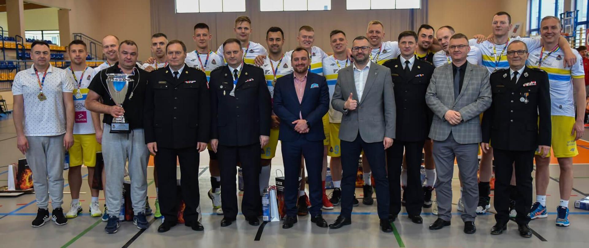 zwycięska drużyna pozuje do zdjęcia i organizatorami i sponsorami